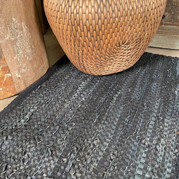 Hand woven black leather and cotton rug, close up