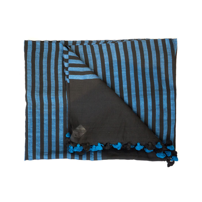 Blue and black stripped scarf with black and blue pompoms, partially unfolded