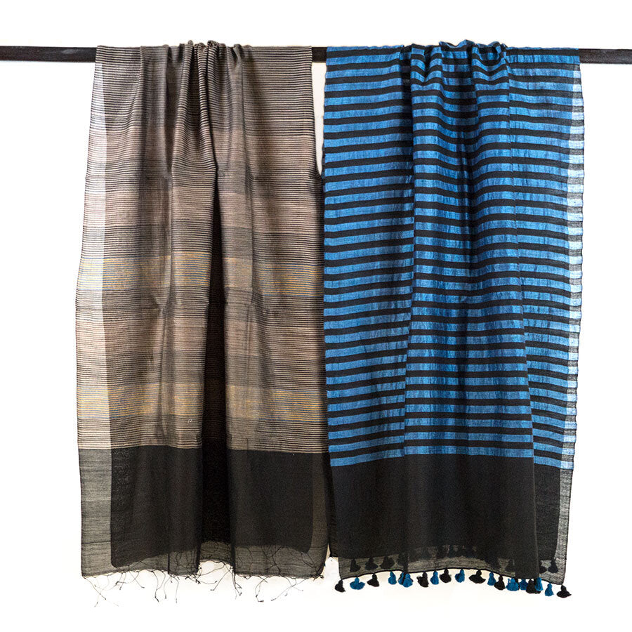 Blue and black stripped scarf with black and blue pompoms, unfolded