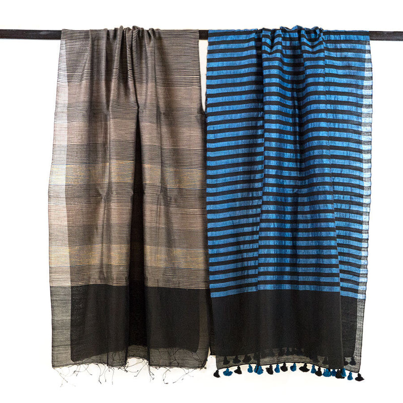 Blue and black stripped scarf with black and blue pompoms, unfolded